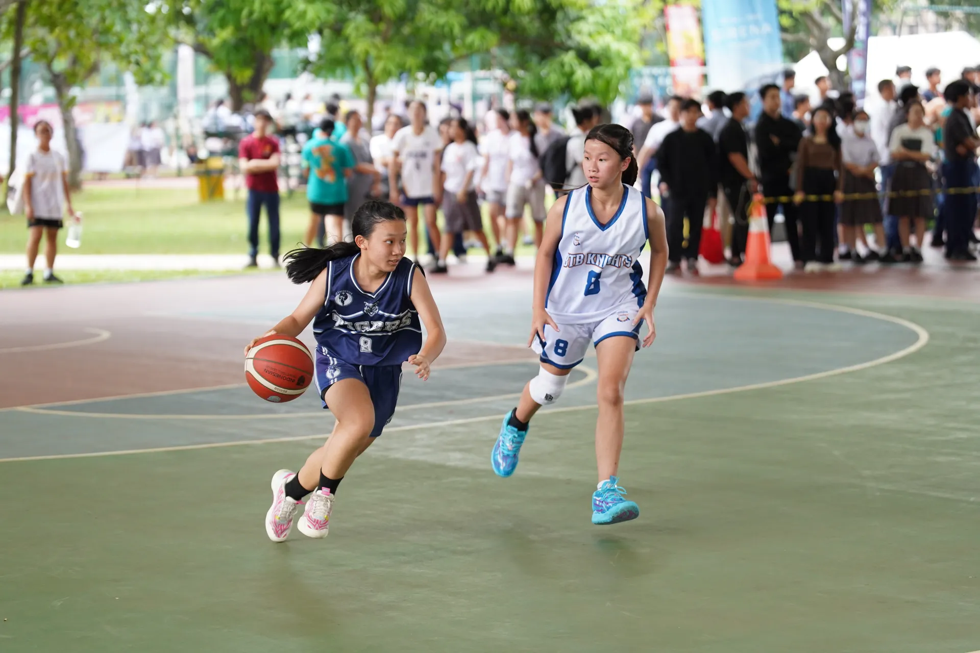 Pemain basket putri mencari kesempatan menyerang